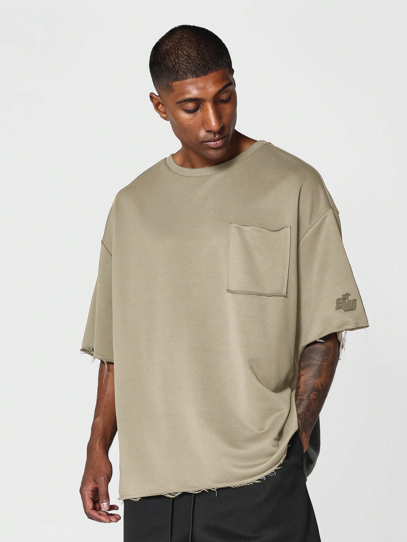 Oversized Fit Raw Edge Tee With Front Pocket And Sleeve Applique