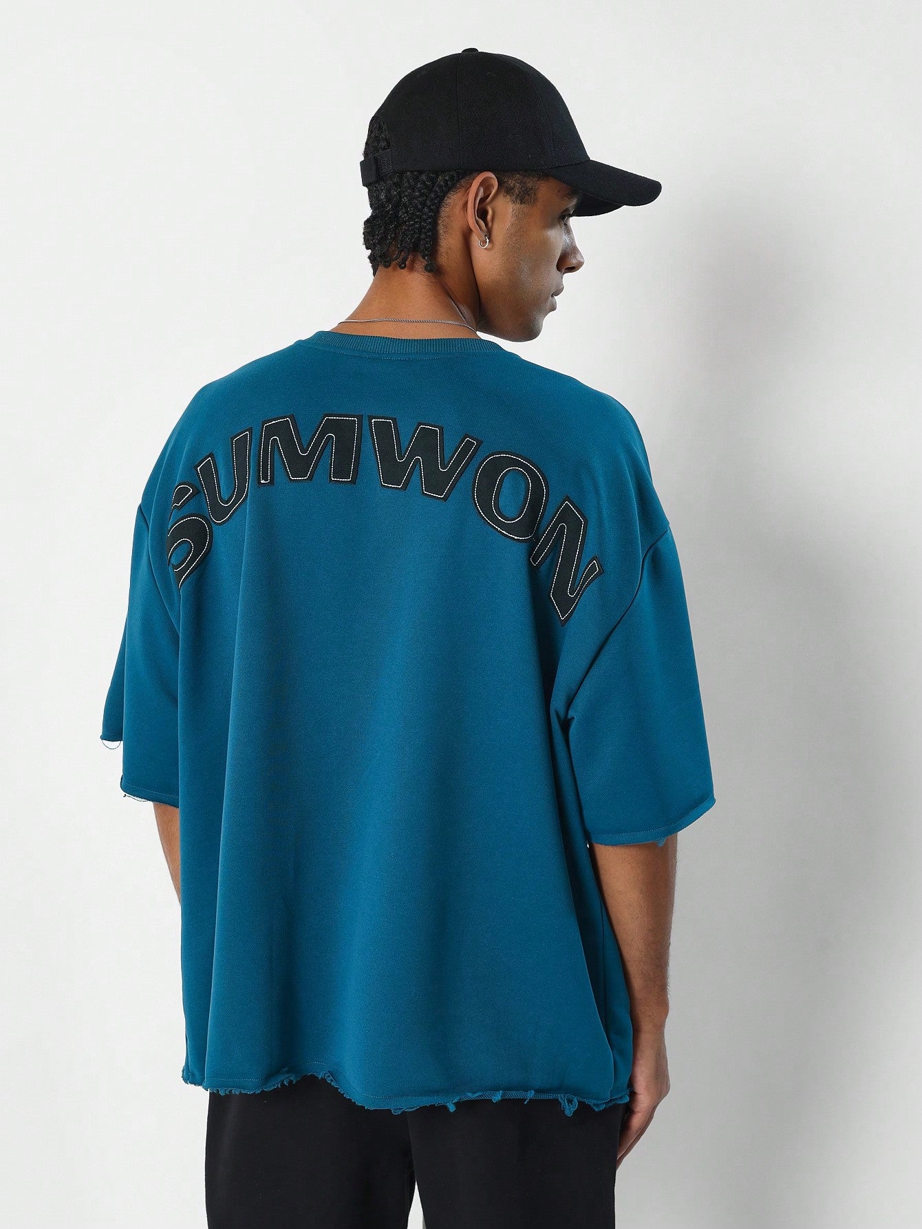 Oversized Fit Raw Edge Tee With Front Pocket And Sleeve Applique