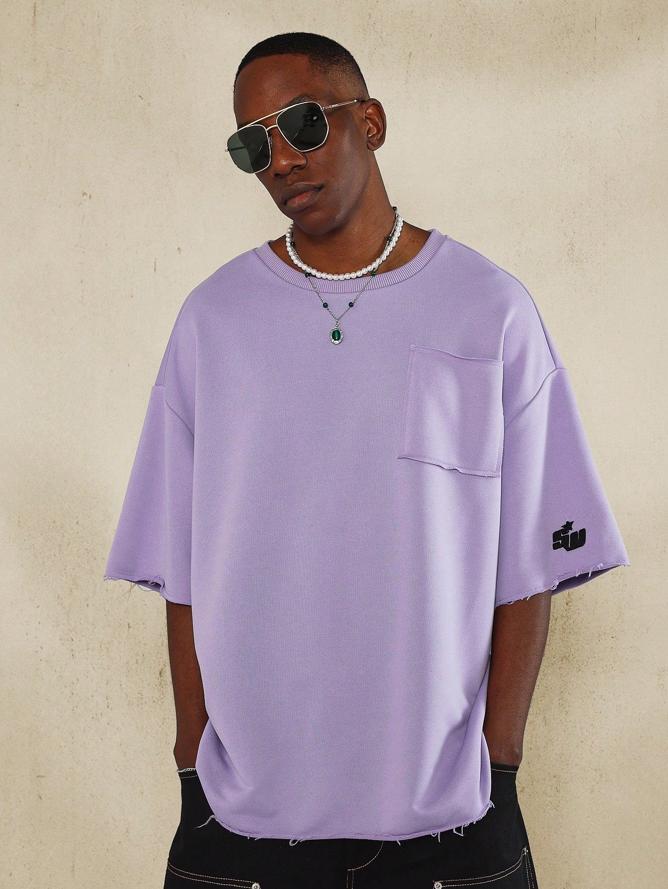 Oversized Fit Raw Edge Tee With Front Pocket And Sleeve Applique