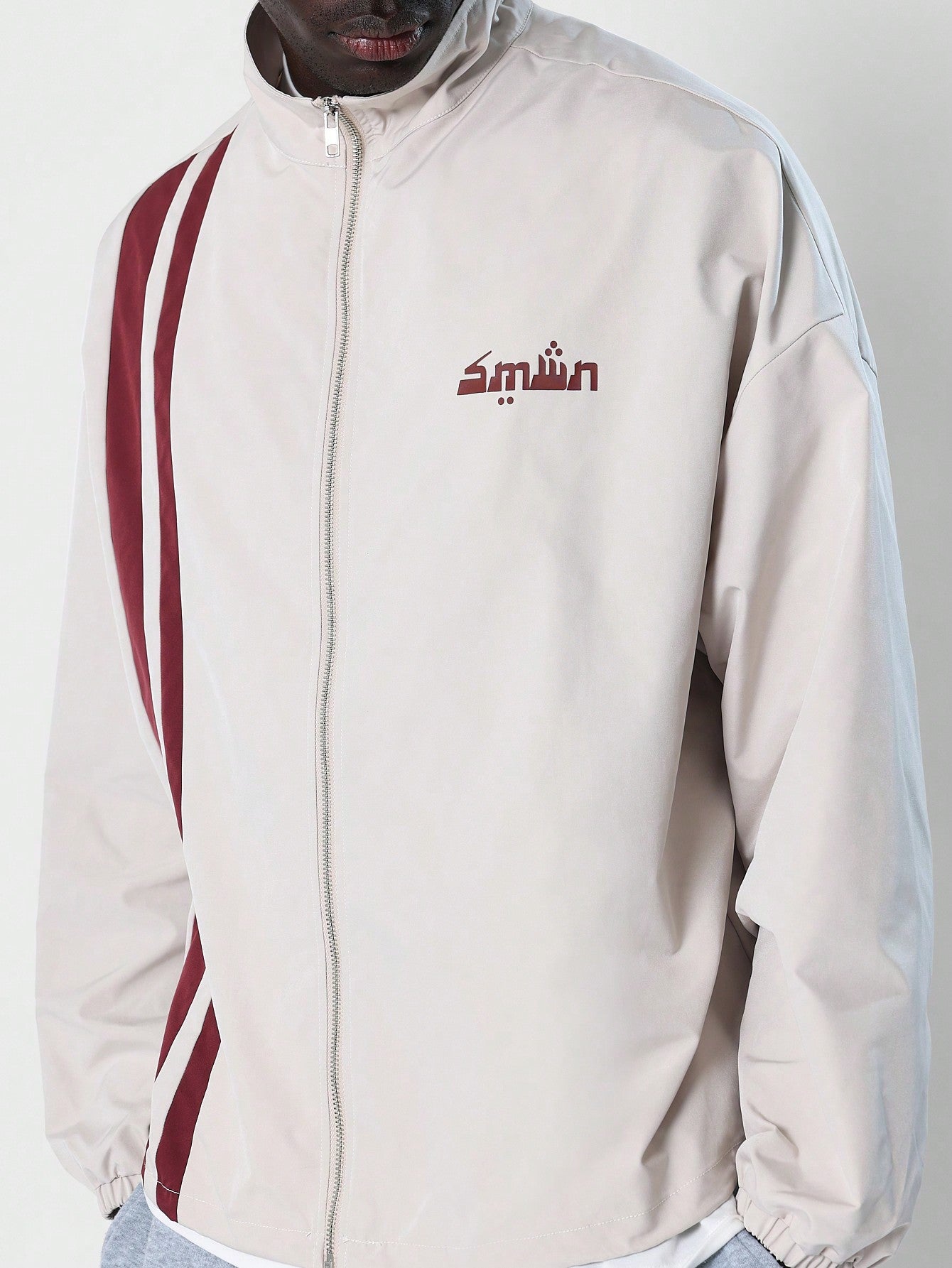 Sporty Nylon Mock Neck Zip Through Track Jacket With Side Stripe And Small Graphic Print