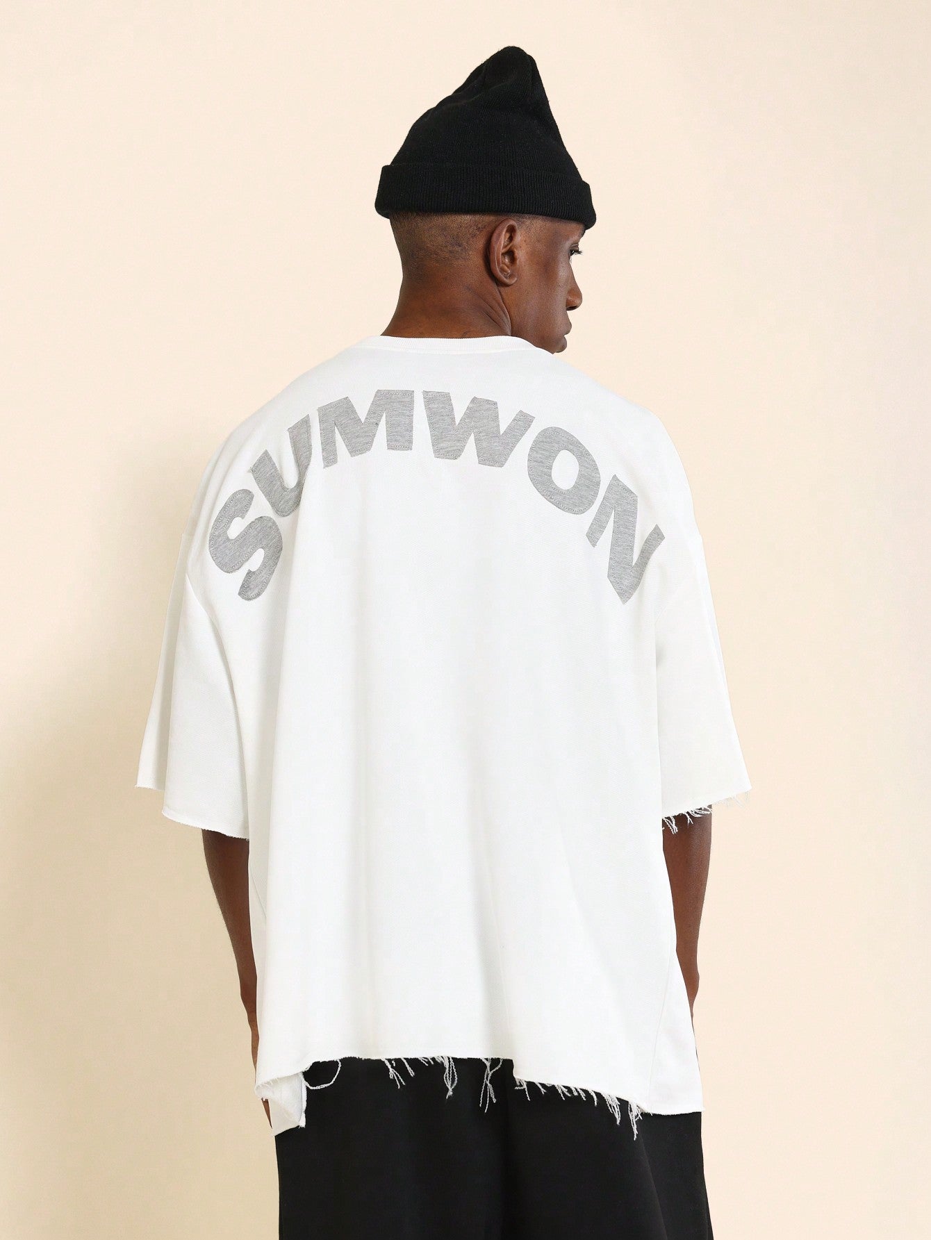 Oversized Fit Raw Edge Tee With Front Pocket And Sleeve Applique