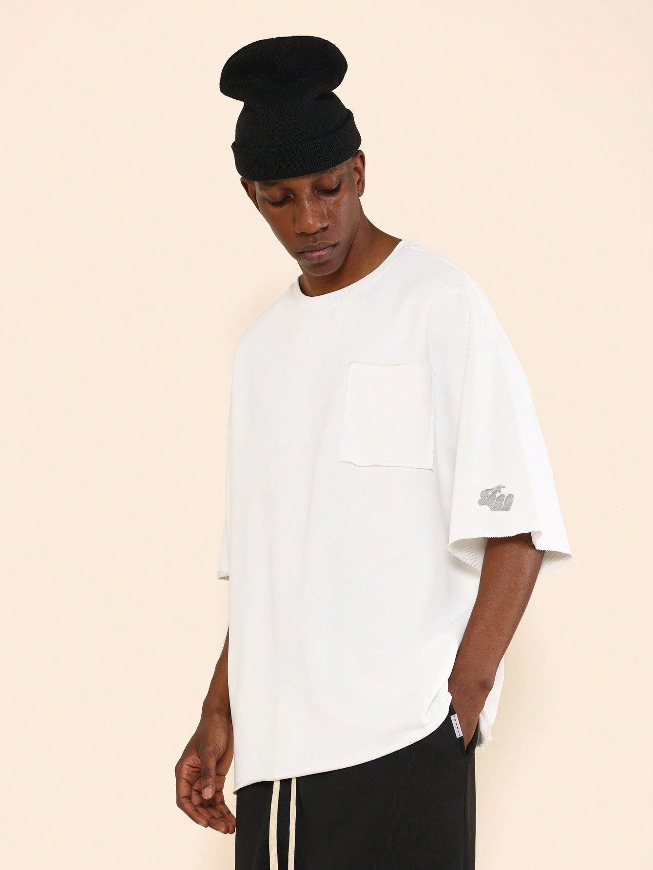 Oversized Fit Raw Edge Tee With Front Pocket And Sleeve Applique